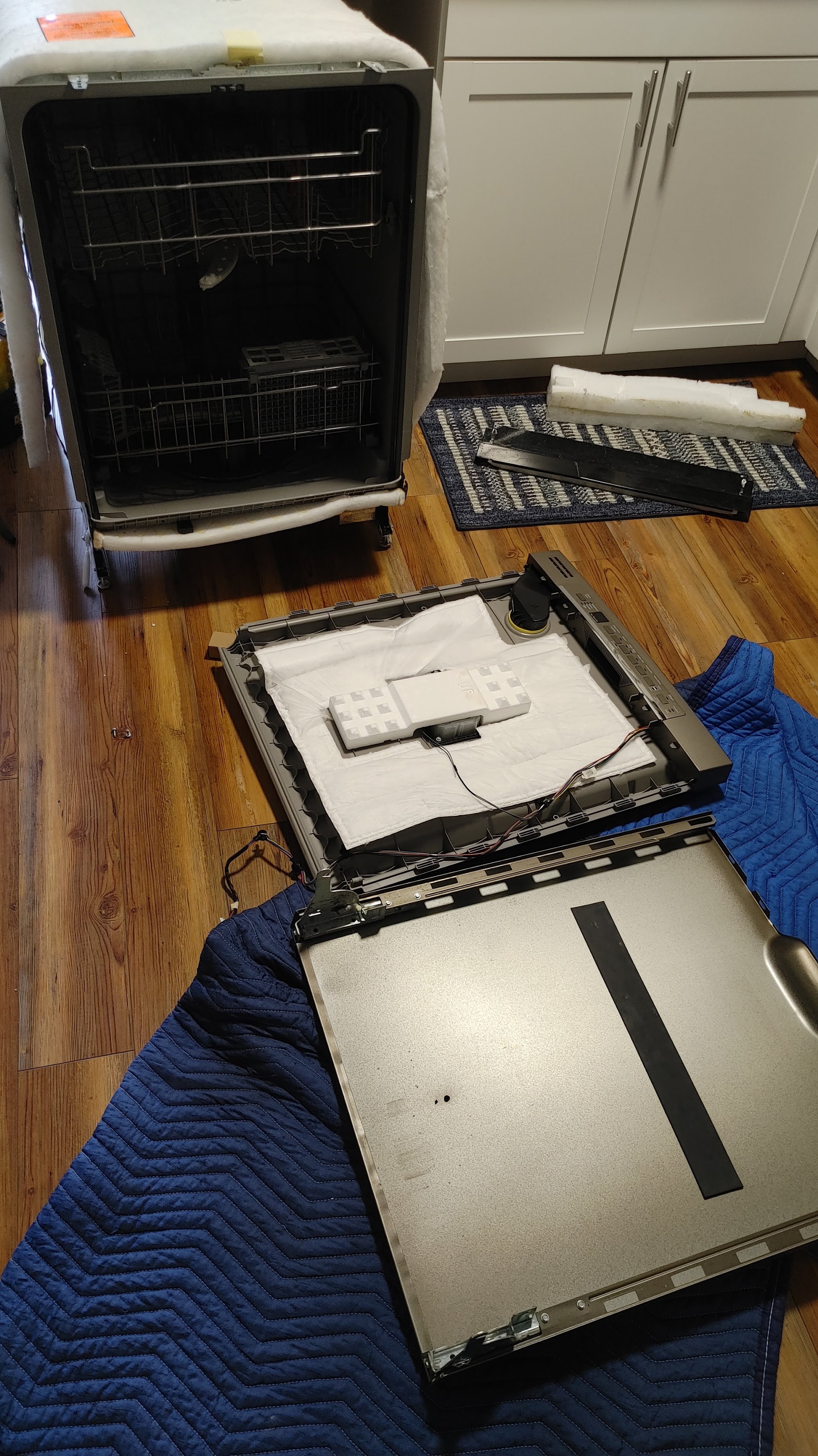 Dishwasher panel opened up on a blanket during a repair